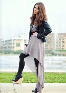Asymmetrical dress in combination with a leather jacket and tight tights.