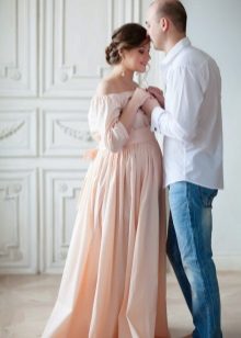Photo shoot for a pregnant woman in a long peach dress