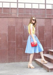 Bright handbag in addition to the blue skirt