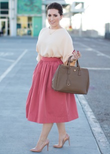 Pink fluffy skirt below the knee in combination with a peach blouse