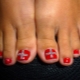 Features create a red pedicure with rhinestones