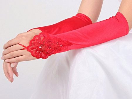 Red gloves in tone to the red ribbon of the wedding dress